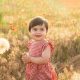 cute-baby-girl-red-dress-holding-large-dandelion-field-poppies-summer-sunset_203451-1439